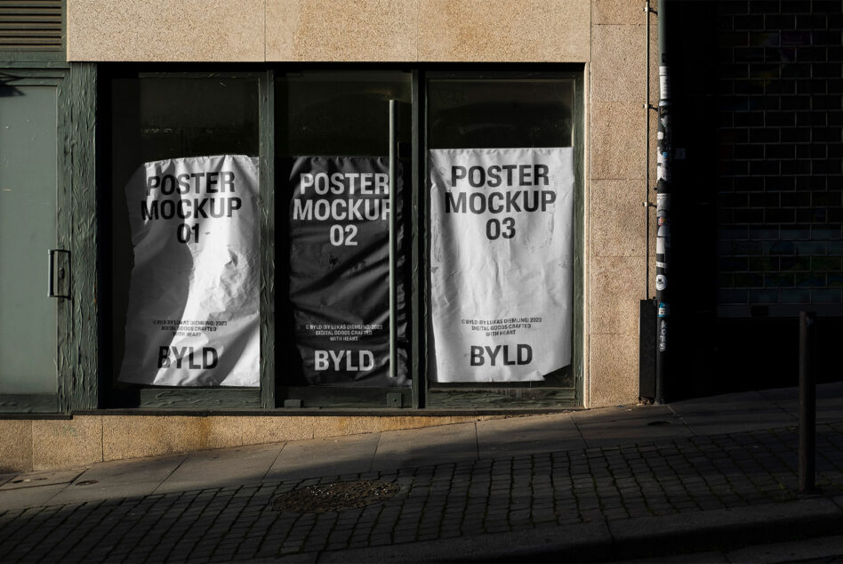 Street poster mockups displayed on urban storefront for designers, showcasing realistic light shadows for graphic presentation.